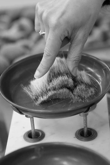 From the bundles, the exact amount of hair or fibre needed is selected and weighed to ensure consistency from brush to brush.
